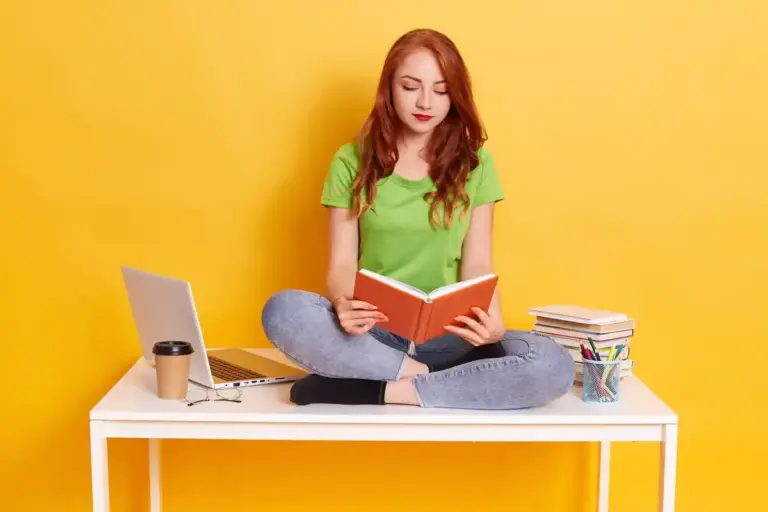 student studying actively with books and laptop